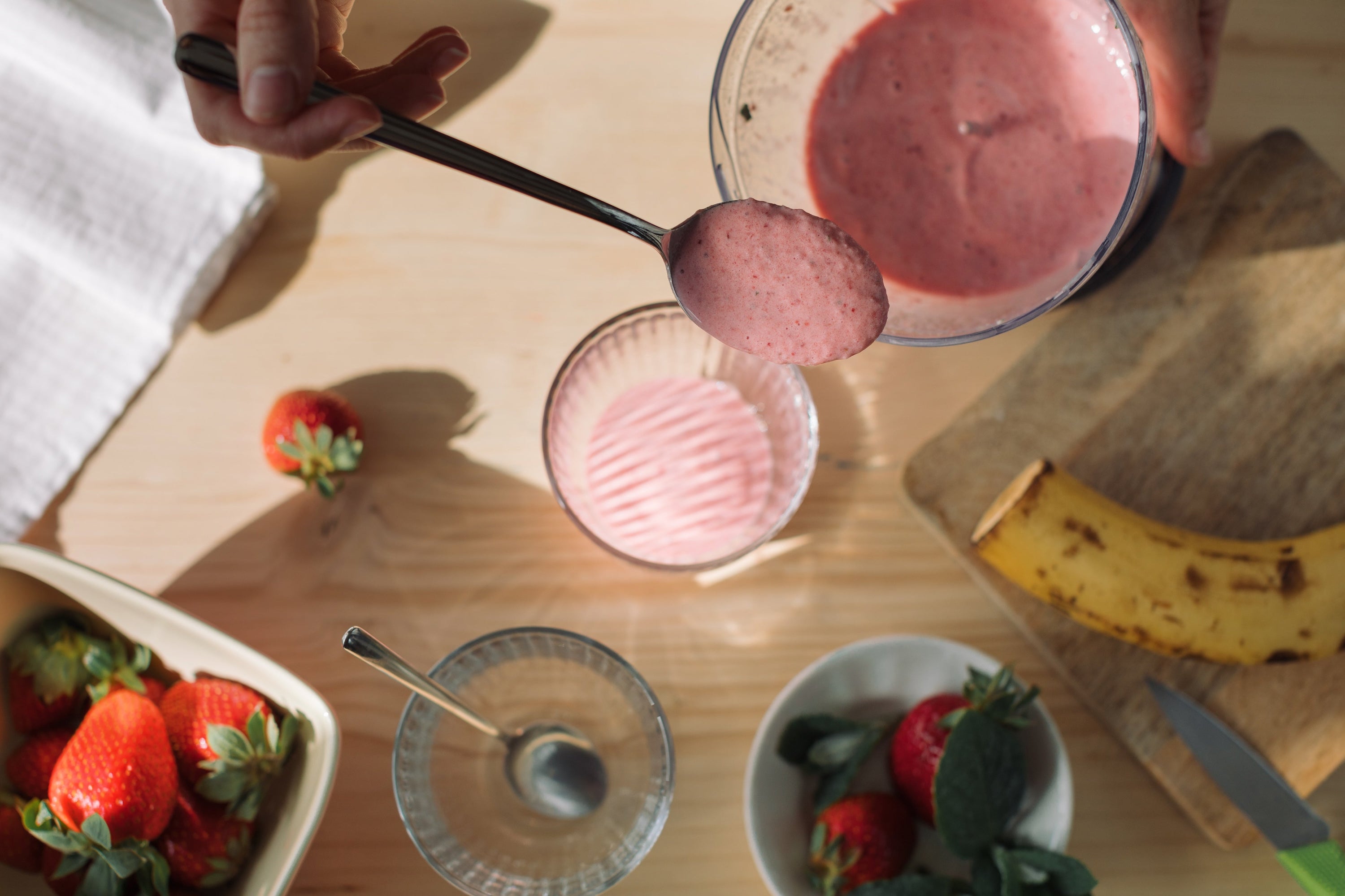 woman preparing nice cream in kitchen with fruit